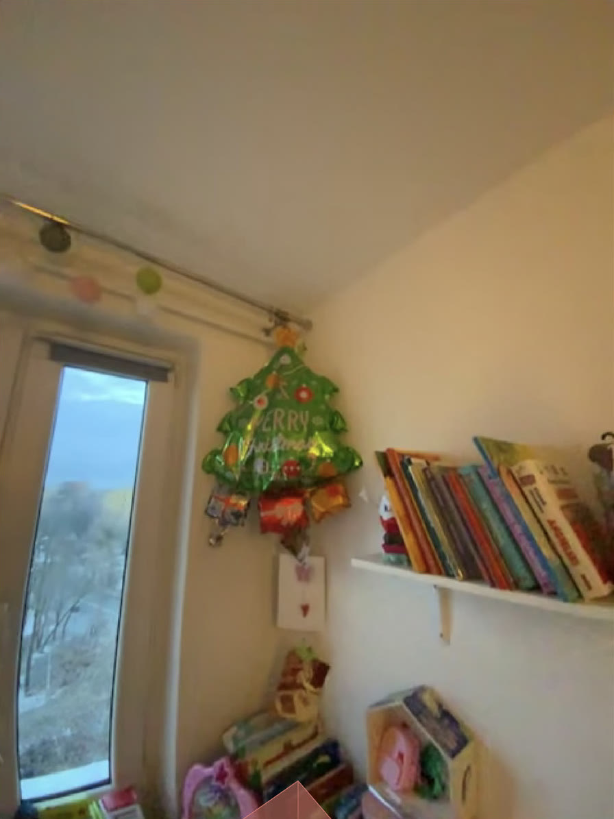 The ultrawide camera on the same corner, additionally showing the window, the full bookshelf, and the toys on the floor.